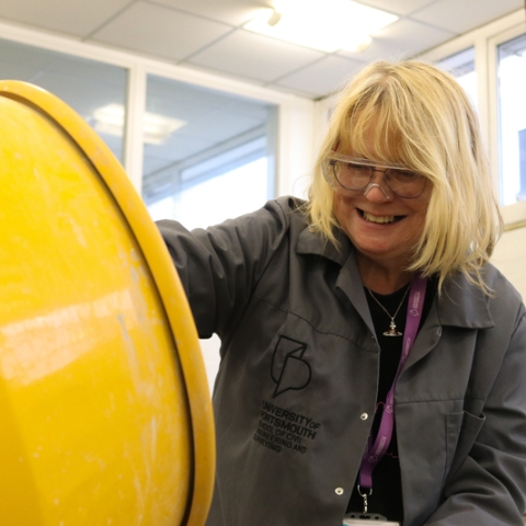 A woman with glasses using cement mixer