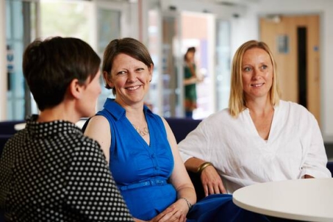 Three women sat down chatting