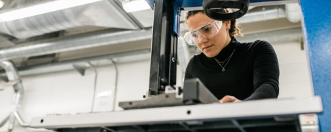A woman in black top using machinery