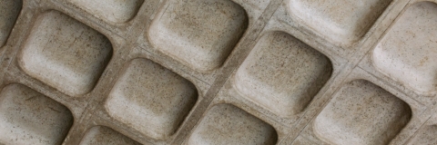 A grey textured surface with uniform rectangular indents.