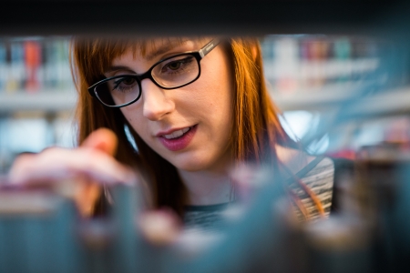 A student browsing books in the library